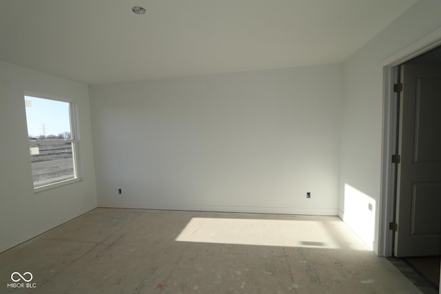unfurnished room with baseboards