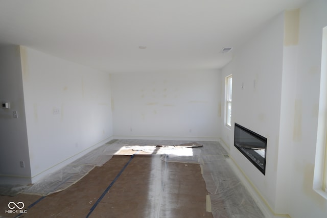 unfurnished living room with visible vents and a glass covered fireplace