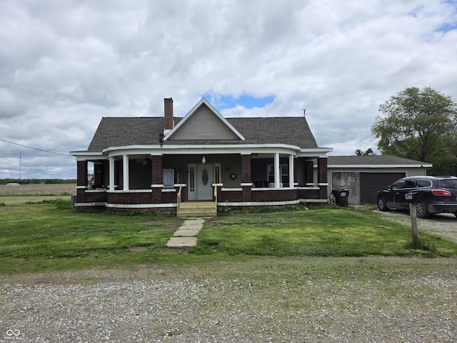 view of front of house featuring a front yard, a porch, brick siding, and a garage