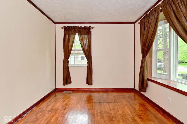 7228 Kimberly Ln, Plainfield, IN 46168 - empty room with hardwood / wood-style floors, healthy amount of natural light, crown molding, baseboards, and a textured ceiling
