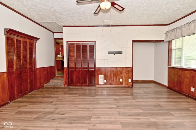7228 Kimberly Ln, Plainfield, IN 46168 - unfurnished room featuring wooden walls, crown molding, ceiling fan, wood finished floors, and a textured ceiling