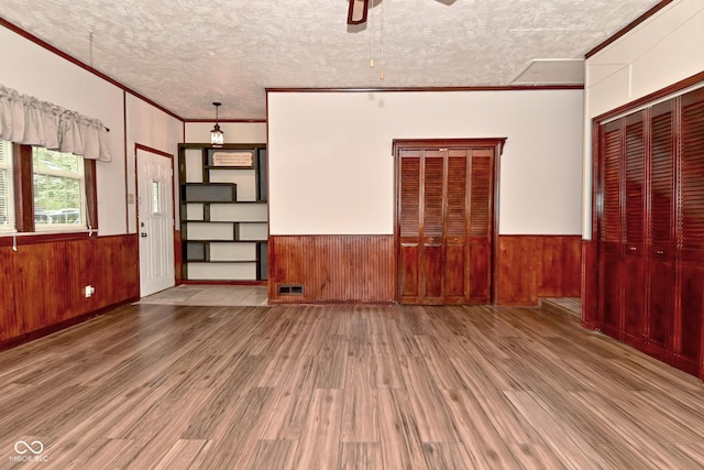 7228 Kimberly Ln, Plainfield, IN 46168 - unfurnished room with wood finished floors, ornamental molding, wooden walls, a ceiling fan, and wainscoting