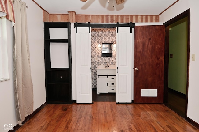 7228 Kimberly Ln, Plainfield, IN 46168 - unfurnished bedroom featuring hardwood / wood-style flooring, a barn door, and a sink