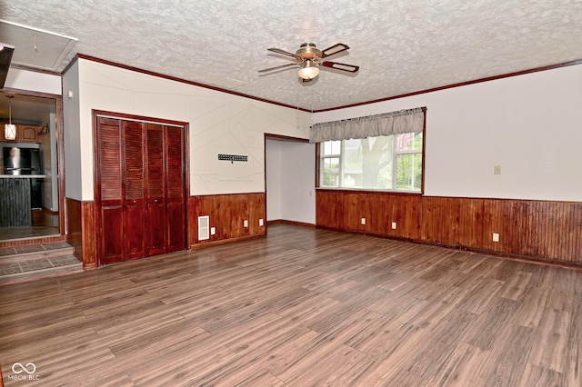 7228 Kimberly Ln, Plainfield, IN 46168 - empty room featuring wooden walls, a ceiling fan, attic access, crown molding, and wood finished floors