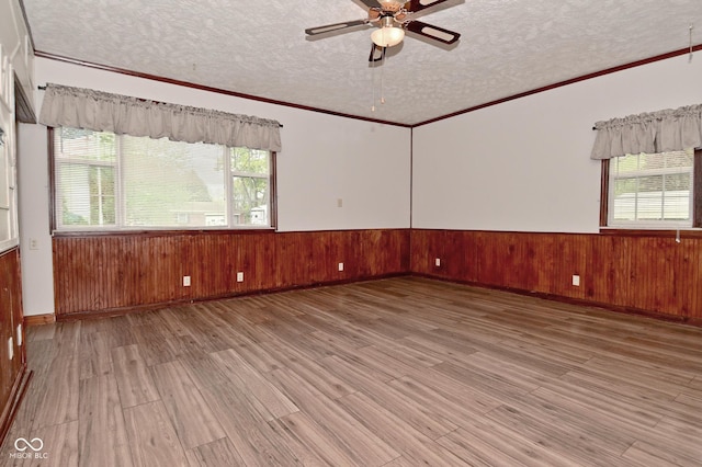 7228 Kimberly Ln, Plainfield, IN 46168 - empty room with a textured ceiling, wood finished floors, ceiling fan, wainscoting, and wooden walls