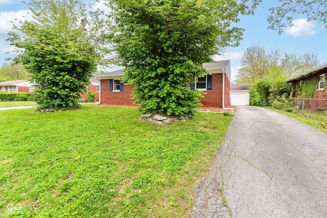 obstructed view of property featuring a garage, brick siding, a front lawn, and fence
