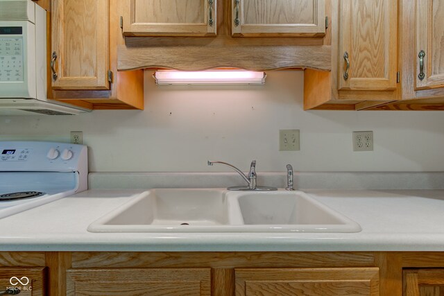 kitchen with a sink, light countertops, and white appliances