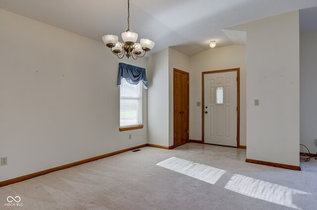 foyer with plenty of natural light, light colored carpet, a chandelier, and baseboards