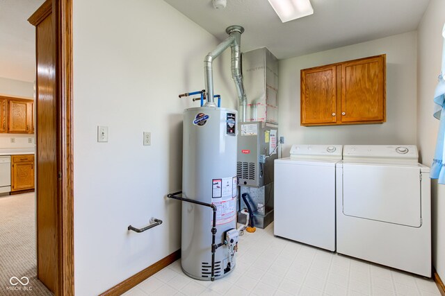 clothes washing area featuring water heater, cabinet space, washer and clothes dryer, and baseboards