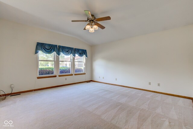 unfurnished room featuring lofted ceiling, ceiling fan, light colored carpet, and baseboards