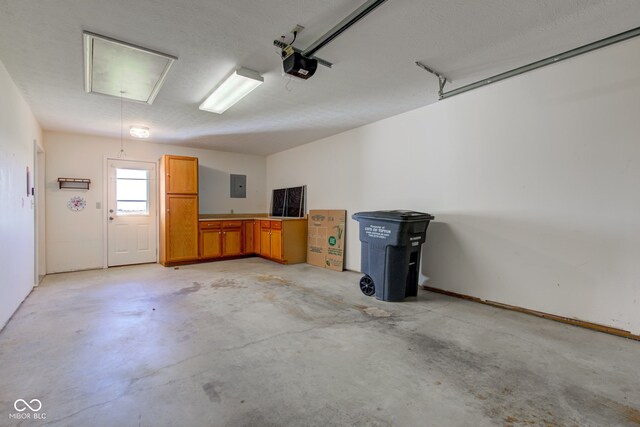 garage with electric panel and a garage door opener
