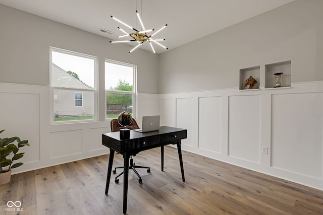 office with light wood-type flooring, visible vents, a decorative wall, and wainscoting