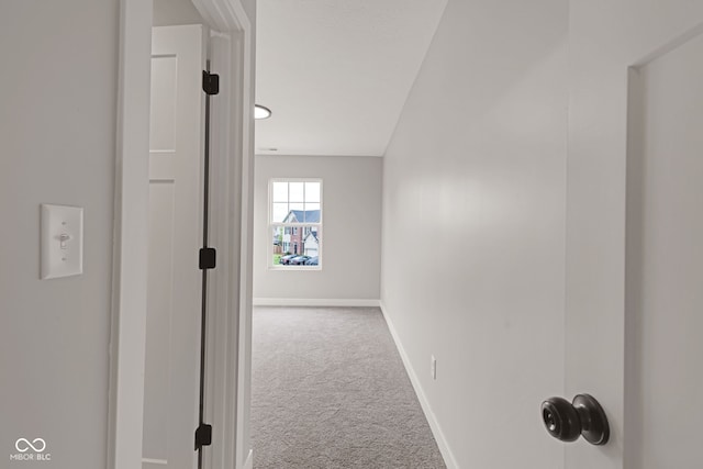 hallway with carpet floors and baseboards