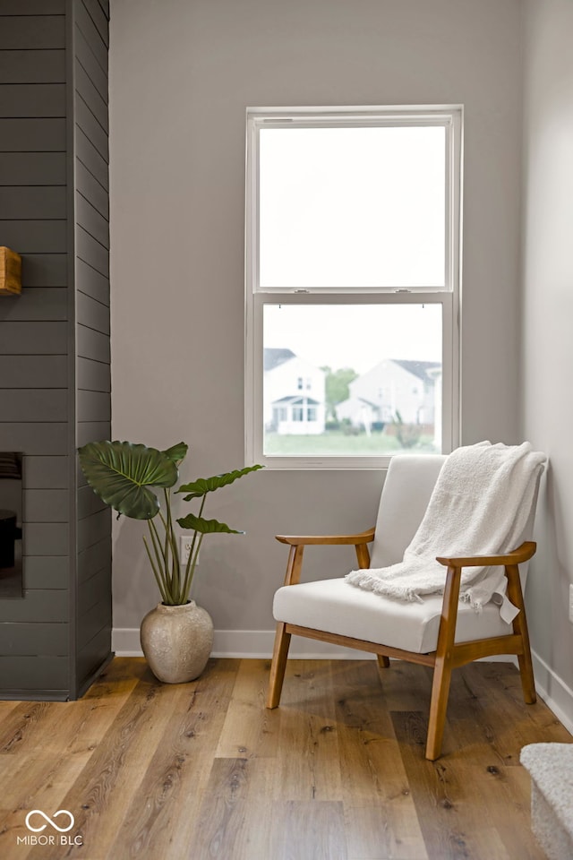 living area with baseboards and wood finished floors