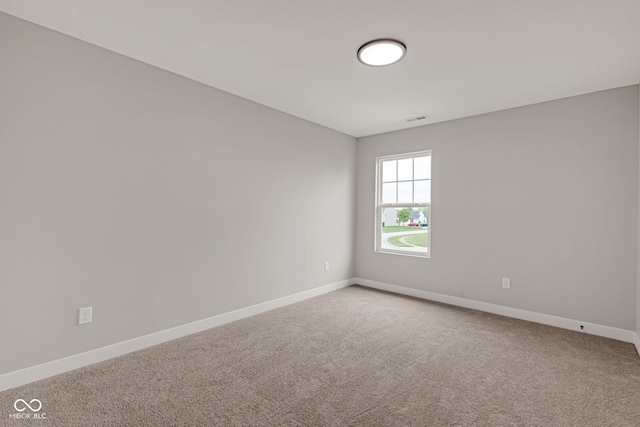 carpeted spare room featuring baseboards and visible vents