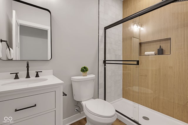 full bath featuring toilet, vanity, and a stall shower