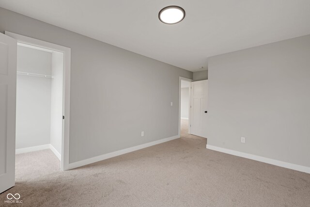 unfurnished bedroom with carpet, a closet, and baseboards