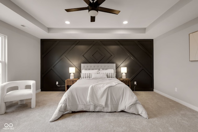 carpeted bedroom with a decorative wall, baseboards, visible vents, and recessed lighting