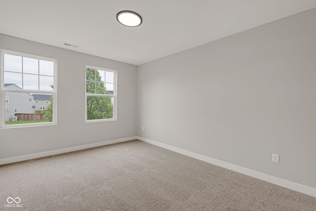 unfurnished room with baseboards, visible vents, and carpet floors