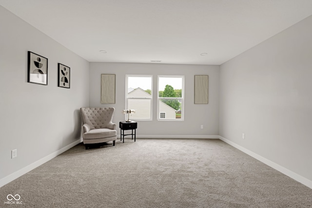 sitting room featuring baseboards and carpet
