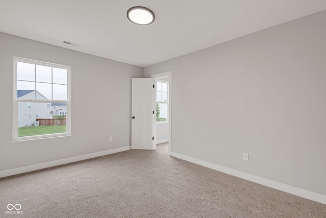empty room featuring visible vents, baseboards, and carpet floors