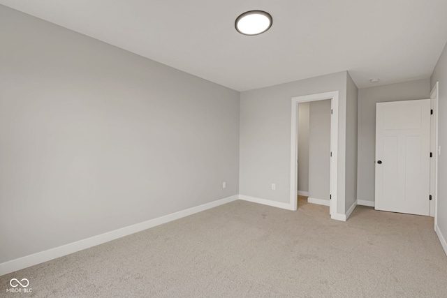 unfurnished bedroom featuring light colored carpet and baseboards
