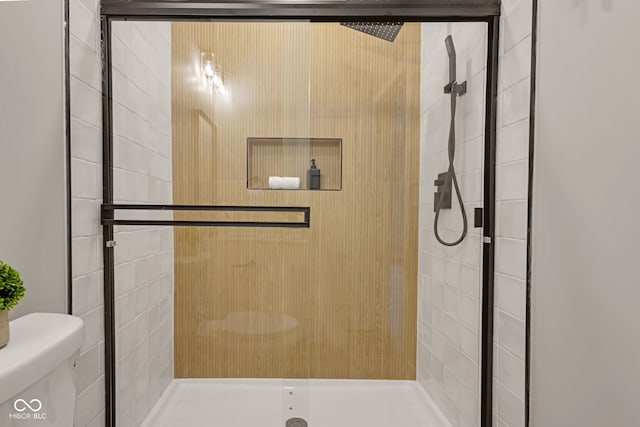 bathroom with a stall shower and toilet