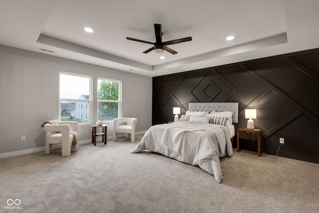 bedroom featuring a tray ceiling, visible vents, light colored carpet, and recessed lighting