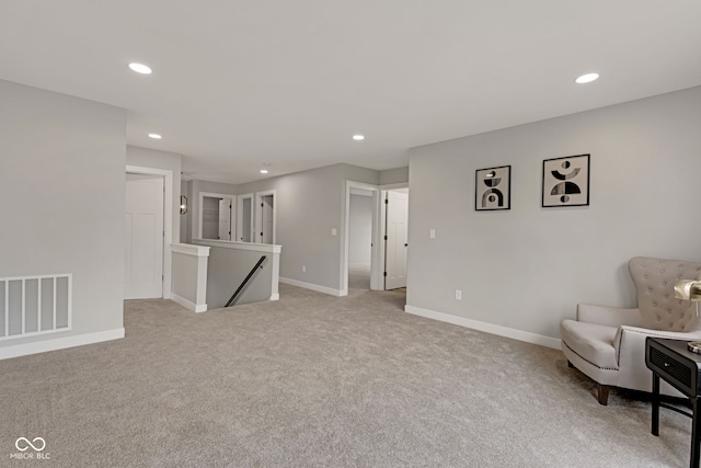 sitting room with recessed lighting, an upstairs landing, visible vents, and light colored carpet