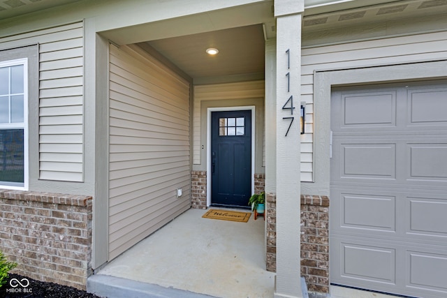 doorway to property featuring brick siding and covered porch