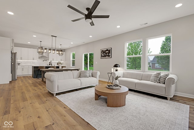 living area with recessed lighting, baseboards, light wood finished floors, ceiling fan, and visible vents