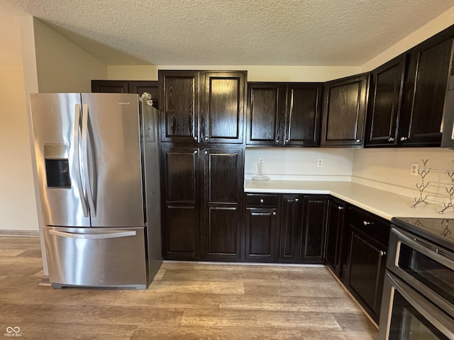 2725 Falcon Ct, Seymour, IN 47274 - kitchen featuring stainless steel fridge with ice dispenser, a textured ceiling, light wood-style flooring, range with two ovens, and light countertops