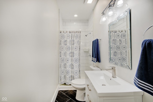 bathroom with toilet, a tile shower, vanity, and baseboards