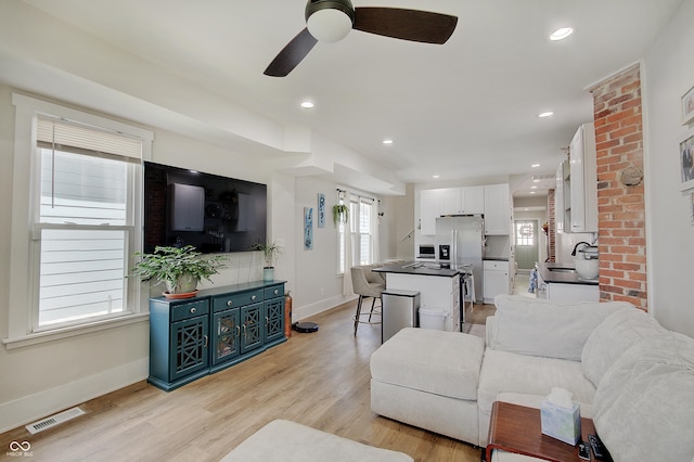 living room with a ceiling fan, baseboards, light wood-style floors, and recessed lighting