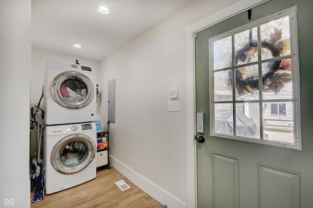 laundry room with stacked washer / dryer, baseboards, light wood-style flooring, healthy amount of natural light, and recessed lighting