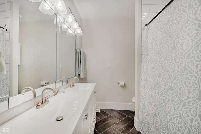 full bathroom featuring toilet, baseboards, double vanity, and curtained shower