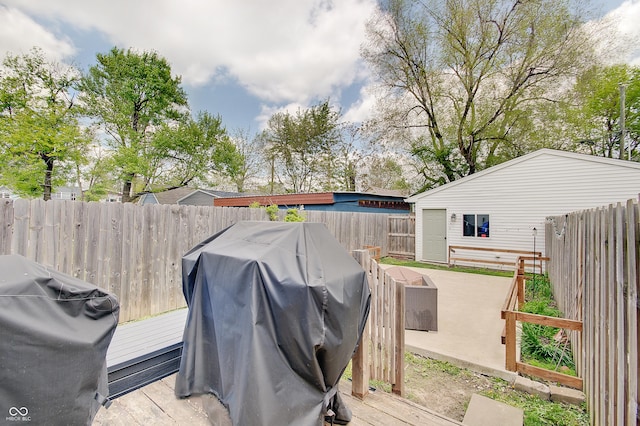 wooden deck featuring a fenced backyard and a grill