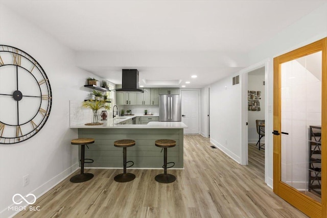 6682 English Dr, Avon, IN 46123 - kitchen featuring freestanding refrigerator, island range hood, a sink, light countertops, and a breakfast bar