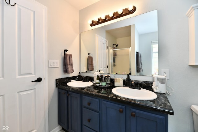 full bath with a shower stall, toilet, double vanity, and a sink