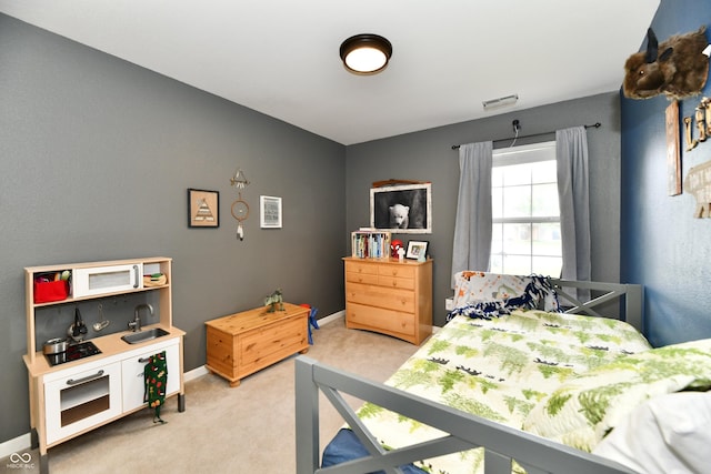 bedroom featuring light carpet and baseboards