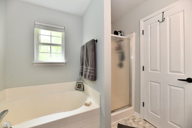 bathroom with a stall shower and a garden tub