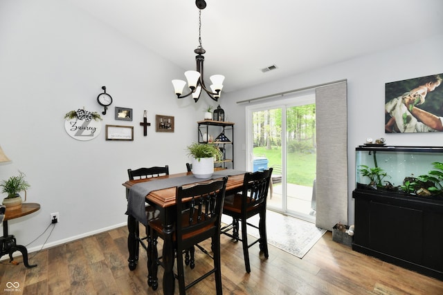dining room featuring baseboards, a chandelier, visible vents, and wood finished floors