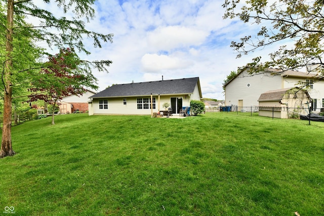 rear view of property with a yard, a patio, and a fenced backyard