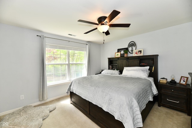 bedroom featuring light colored carpet, visible vents, baseboards, and ceiling fan