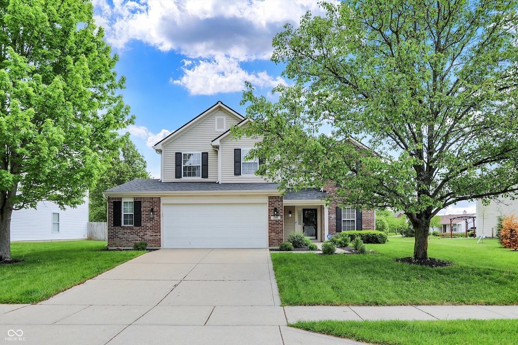 traditional-style house featuring concrete driveway, a front yard, brick siding, and an attached garage