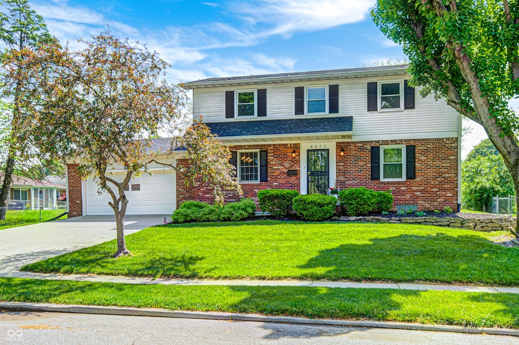 6030 Cadillac Dr, Indianapolis, IN 46224 - traditional-style house featuring brick siding, a front lawn, concrete driveway, and a garage