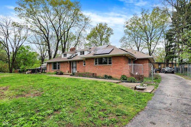 3975 Denwood Dr, Indianapolis, IN 46226 - view of front of property with roof mounted solar panels, brick siding, and roof with shingles