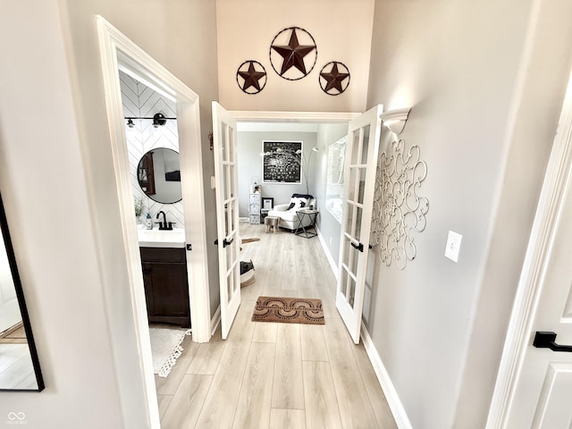 14035 Stone Key Way, Fishers, IN 46037 - hall with french doors, light wood-type flooring, a sink, and baseboards