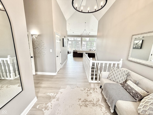 14035 Stone Key Way, Fishers, IN 46037 - corridor with high vaulted ceiling, a chandelier, baseboards, and wood finished floors