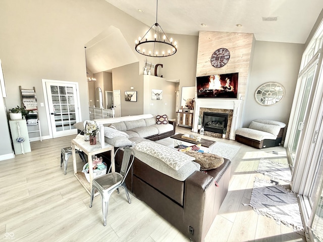 14035 Stone Key Way, Fishers, IN 46037 - living area featuring a chandelier, high vaulted ceiling, light wood finished floors, a high end fireplace, and baseboards